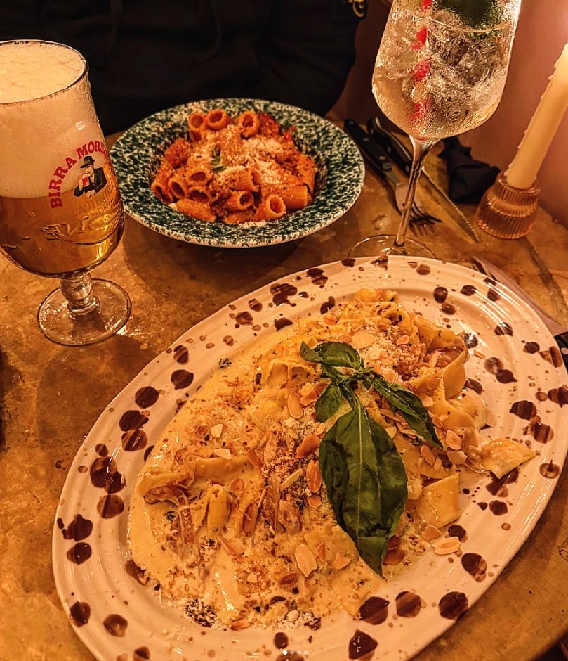 An evening table at Norma with two pasta dishes, Sicilian beer and a spritz
